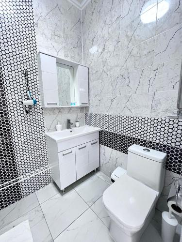 La salle de bains blanche est pourvue de toilettes et d'un lavabo. dans l'établissement ЖК Legenda Абая 109/6 49, à Almaty