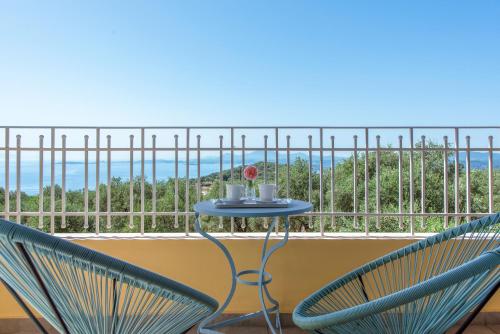 2 sedie e un tavolo sul balcone di Terra Rossa by Konnect, Views to Ionian Sea a Spartýlas