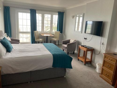 a bedroom with a bed and a table and chairs at St Magloire in Saint Aubin