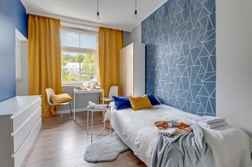 a bedroom with a large bed with a blue wall at Gdynia Stacja 24/7 in Gdynia