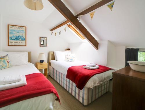a bedroom with two beds and a sink in it at Trecarian in Port Isaac