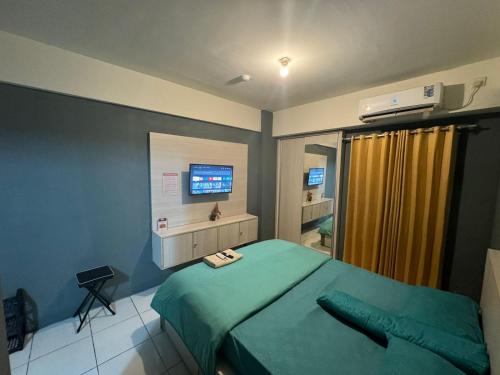 una camera con letto verde e televisore di Jasmin Park Apartemen By Fix's Room a Kedungbadak