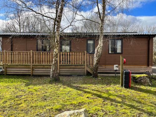 a house with a wooden fence and two trees at Coniston View 7 in Warton