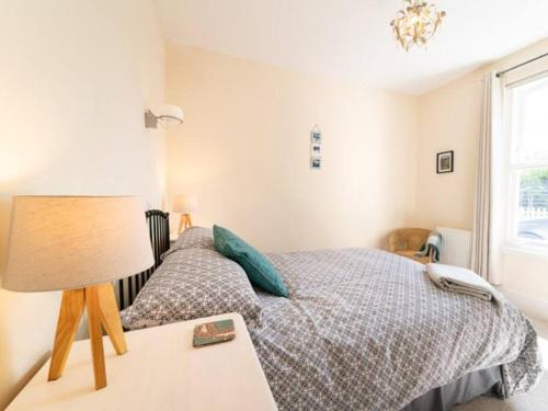 a bedroom with a bed and a table with a lamp at Deerside, Tobermory in Tobermory
