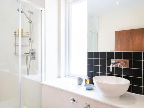 a bathroom with a sink and a glass shower at Deerside, Tobermory in Tobermory