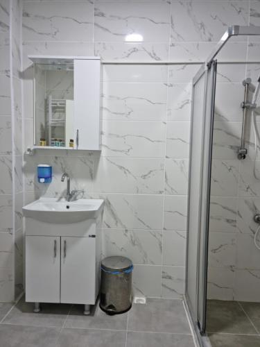 a white bathroom with a sink and a shower at Choras Butik Otel in Şarköy