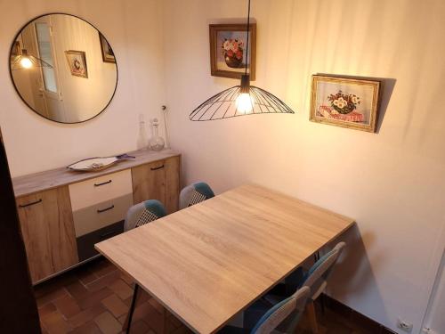- une salle à manger avec une table en bois et un miroir dans l'établissement Côté Mer - Les Gîtes de la Côte d'Amour, au Croisic