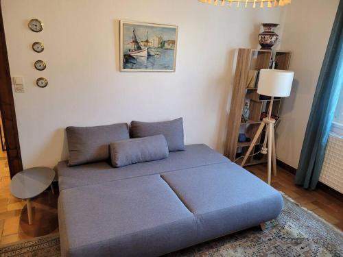 uma sala de estar com um sofá azul num quarto em Côté Mer - Les Gîtes de la Côte d'Amour em Le Croisic