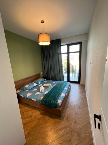 een slaapkamer met een bed en een groot raam bij Archi apartments 4 in Tbilisi City