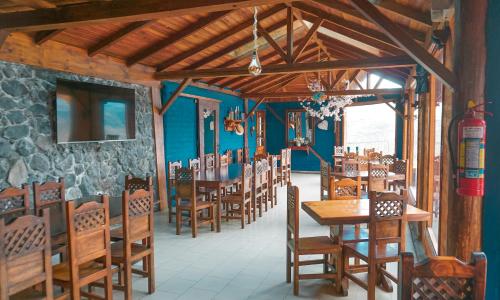 uma sala de jantar com mesas e cadeiras de madeira em Glamping La Montaña 