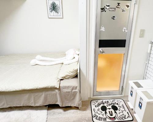 Dormitorio pequeño con cama y espejo en 東新宿1分&新大久保10分 NiNi, en Tokio