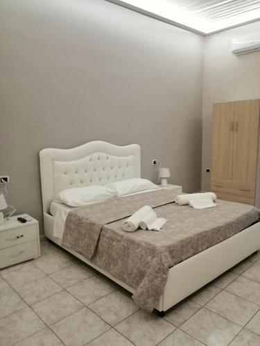 una camera bianca con un grande letto con due asciugamani di Francesco Home a Napoli