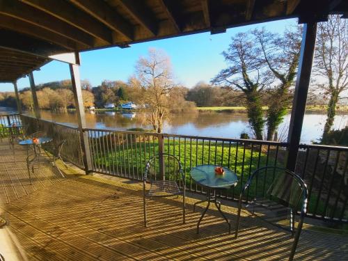 a porch with a table and chairs and a view of a river at The Lenchford in Worcester