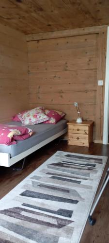 1 dormitorio con 1 cama y pared de madera en DesAlpes, en Saxeten