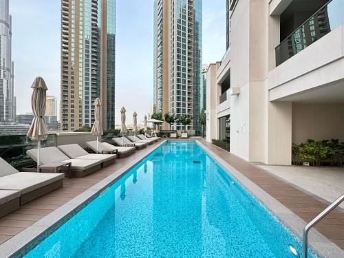 a swimming pool with lounge chairs and a building at Burj khalifa and fountain view 2bedrooms in Dubai