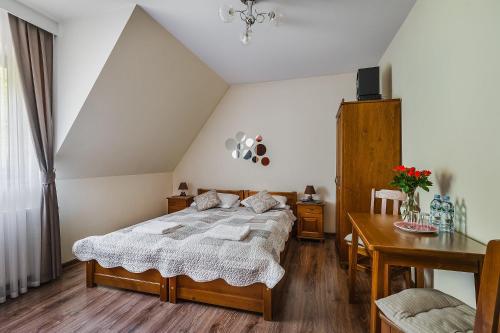 a bedroom with a large bed and a table at WillaByTheRiver JACUZZI & SAUNA in Poronin