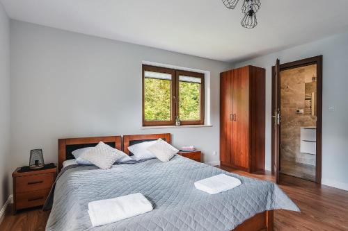 a bedroom with a bed with two towels on it at WillaByTheRiver JACUZZI & SAUNA in Poronin
