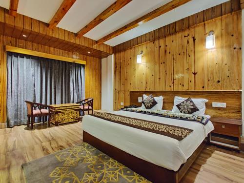 a bedroom with a large bed and wooden walls at Hotel Vajra in Tawang