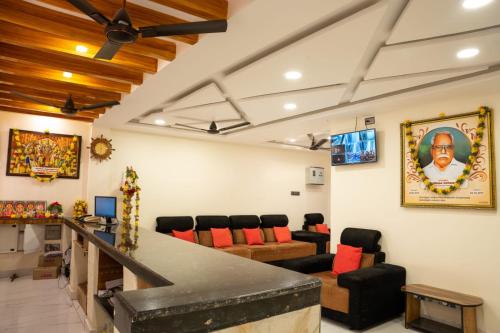 a living room with a ceiling fan and chairs at HOTEL NNP GRAND Rameswaram in Rāmeswaram
