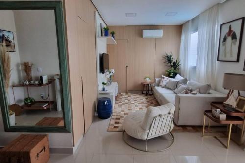 a living room with a couch and a mirror at Linda cobertura em Bertioga in Bertioga