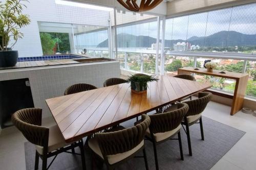 a dining room with a wooden table and chairs at Linda cobertura em Bertioga in Bertioga