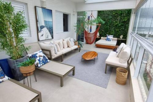 a patio with couches and chairs on a porch at Linda cobertura em Bertioga in Bertioga