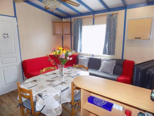 un salon avec une table et un canapé dans l'établissement La Tremblade - DECOUVREZ ce MOBIL-HOME sur un TERRAIN PRIVE, à La Tremblade