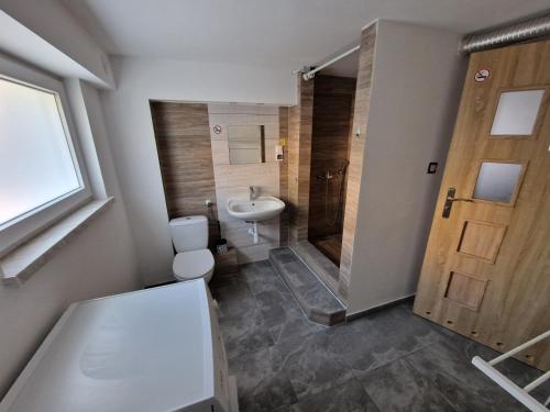 La salle de bains est pourvue de toilettes, d'un lavabo et d'une douche. dans l'établissement Velo Invest, à Koło