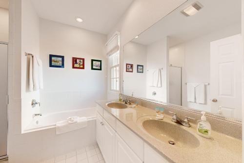 a white bathroom with a sink and a mirror at Bear Trap Dunes---26 Willow Oak Ave in Ocean View