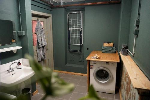 ein Badezimmer mit einer Waschmaschine und einem Waschbecken in der Unterkunft Oide Schreinerei in Steingaden