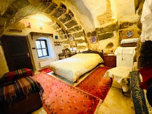 a bedroom with a bed in a stone room at Sofa Hotel in Avanos
