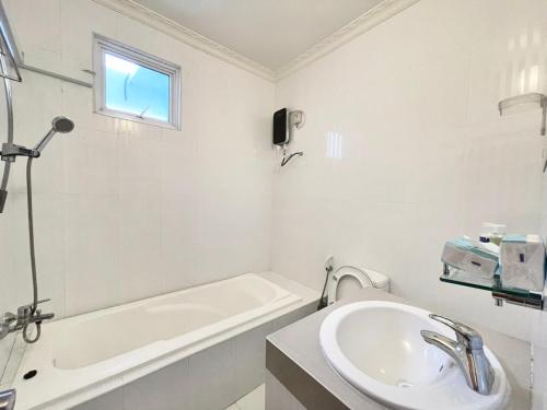 a white bathroom with a sink and a bath tub at Panda holiday 中国酒店 中国餐厅 VX Gsundindi in Rasdu