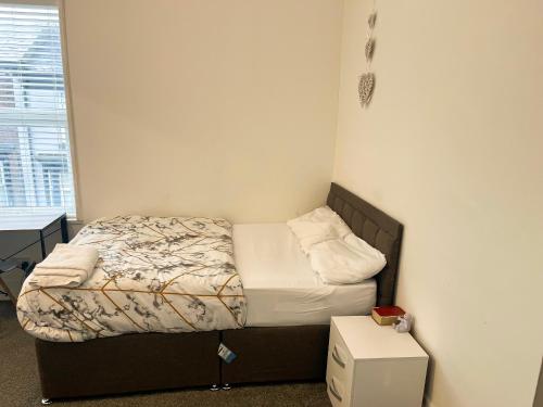 Dormitorio pequeño con cama y mesa en Chizy’s cozy place en Liverpool