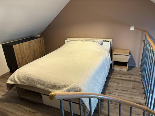 a bedroom with a bed and a stair railing at Maison charmante près de Sains avec spa et jardin clos in Sains