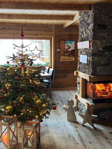a christmas tree in a living room with a fireplace at Boutique Lodge Spycher in Saas-Fee