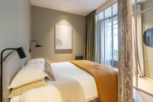 une chambre avec un lit et une grande fenêtre dans l'établissement Marais - Magnificent 3BR/BTH decorated with taste, à Paris