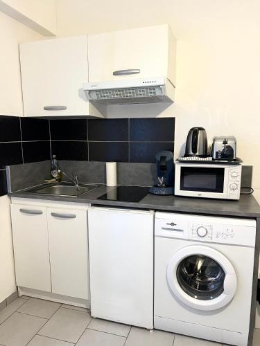 une cuisine avec un lave-linge et un micro-ondes dans l'établissement Studio tout confort cité de la gastronomie (1), à Dijon