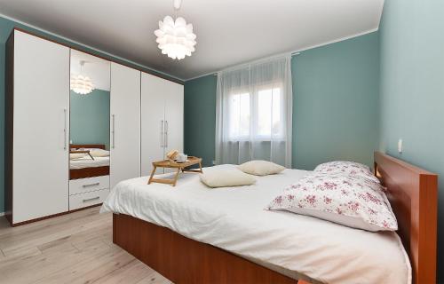 1 dormitorio con 1 cama grande y espejo en Apartment Luka 1481, en Medulin