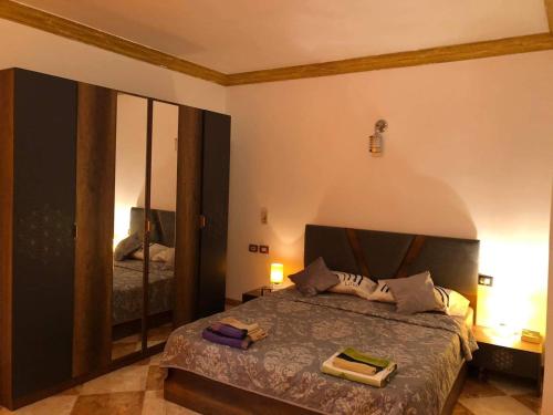1 dormitorio con cama y espejo grande en Schöne Wohnung mit Blick auf Nil und Pyramiden, en El Cairo