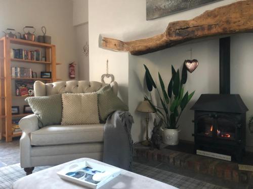 a living room with a couch and a fire place at the old rectory cottage in Pwllheli