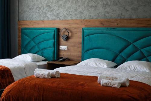 two beds in a hotel room with towels on them at Nafron Hotel in Prizren