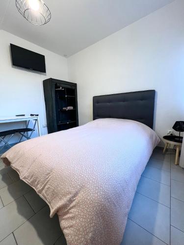 une chambre avec un lit avec une tête de lit noire dans l'établissement Studio tout confort cité de la gastronomie (1), à Dijon