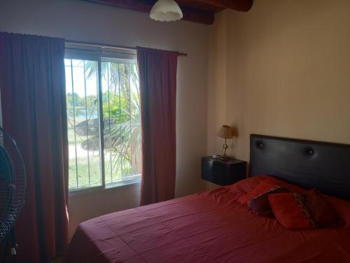 1 dormitorio con cama y ventana grande en Los Duendes de Adriel en San José