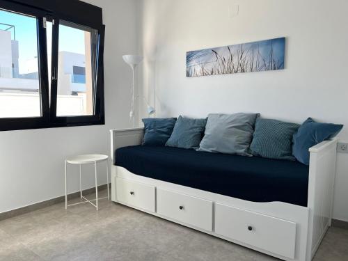 Una cama blanca con almohadas azules en una habitación en Luxury Three Bedroom Villa with Private pool and rooftop Solarium, en San Pedro del Pinatar