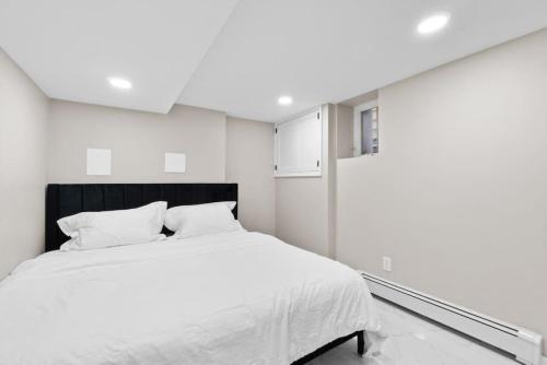 LUX White Marble Retreat near NYC في بايون: غرفة نوم بسرير كبير مع ملاءات بيضاء