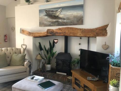 a living room with a tv and a fireplace at the old rectory cottage in Pwllheli