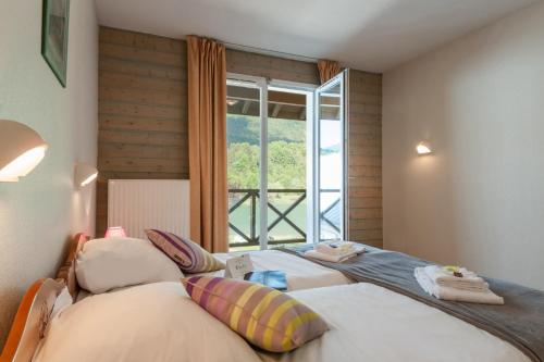 2 camas en una habitación con ventana grande en Eau Vive, en Lescheraines