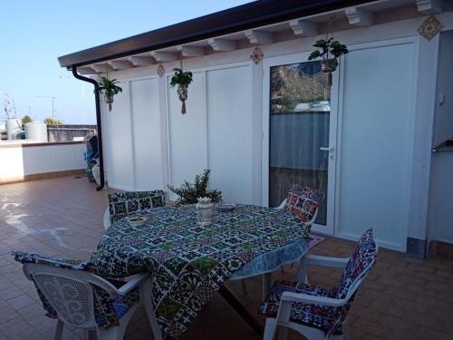 une table et des chaises assises sur une terrasse avec une table et des chaises dans l'établissement La Terrazza Solarium, à Santa Flavia