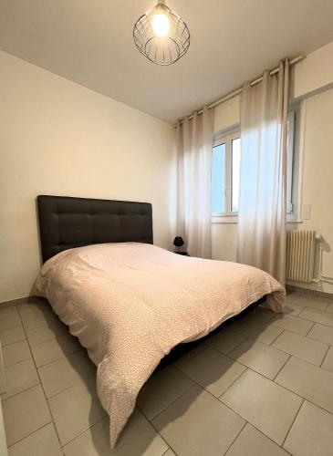 une chambre avec un grand lit et une fenêtre dans l'établissement Studio tout confort cité de la gastronomie (1), à Dijon