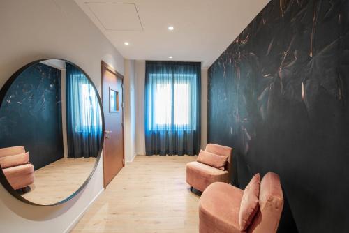 a hallway with a mirror and two chairs in a room at San Carlo Suite Torino in Turin